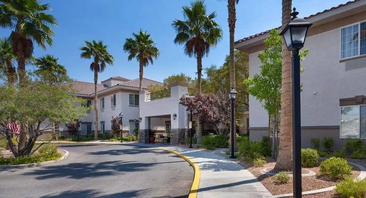 Entrance pathway of Heritage Springs senior living facility with palm trees