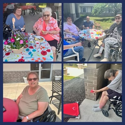 Residents sitting and interacting around tables outdoors.