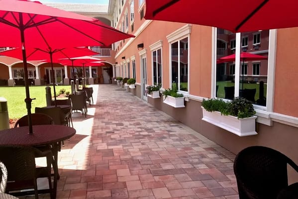 Outdoor seating area with red umbrellas and planters