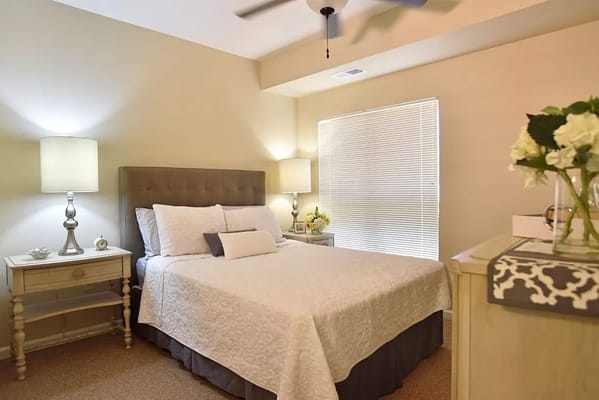 A well-decorated bedroom with a bed, nightstands, and lamps.