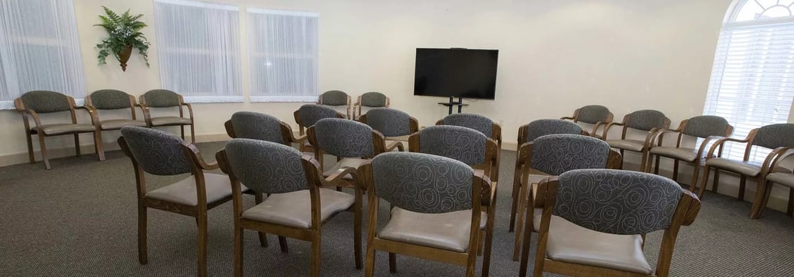 Empty seating in a common area with a television.