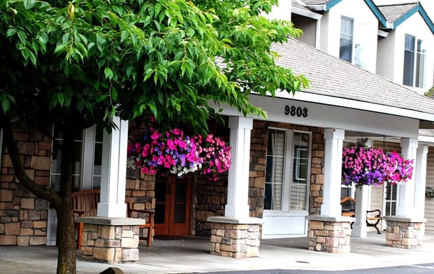 Exterior view of a senior living facility entrance with flowers