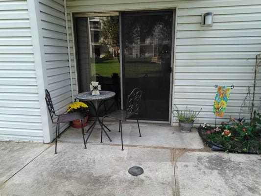 Outdoor patio with a table and chairs near flowers
