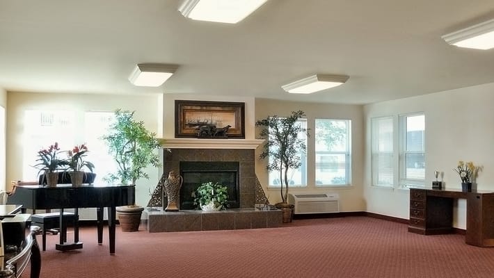 Common area with piano and plants in a cozy setting