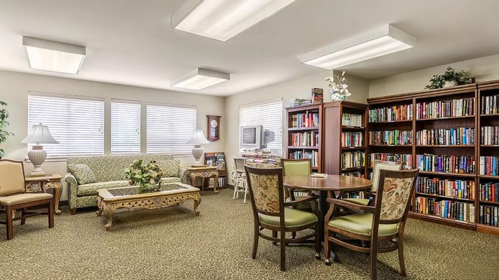 Cozy library lounge with seating and bookshelves at Azalea Park.