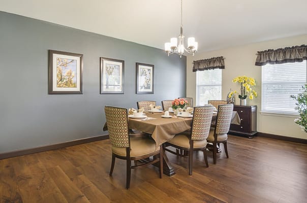 A neatly arranged dining room with a table set for a meal.