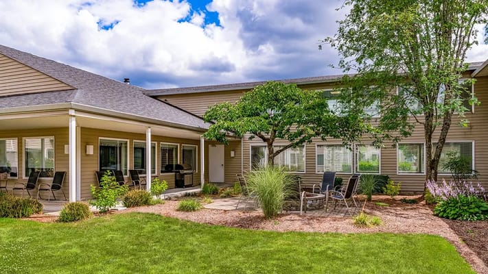 Outdoor seating area with chairs and tables in a landscaped garden