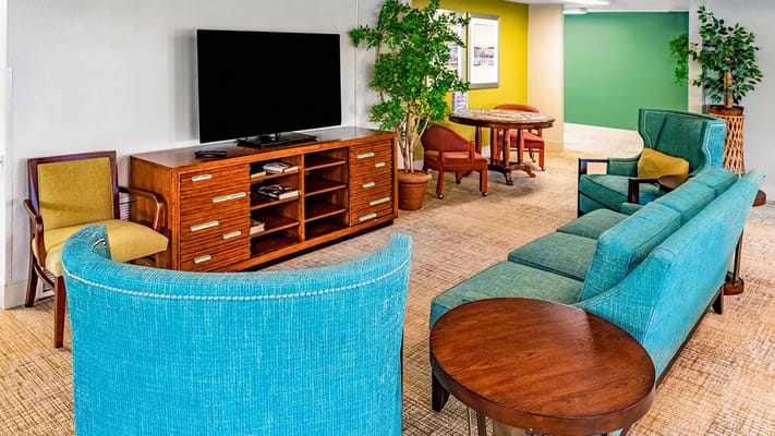 Lounge area with teal seating and wooden furniture