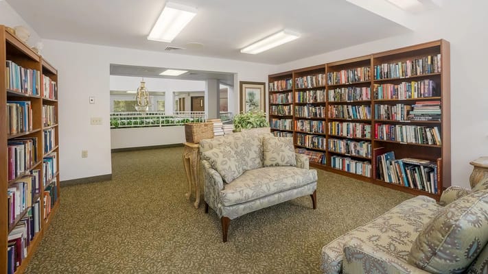 A cozy library space featuring bookshelves and comfortable seating.