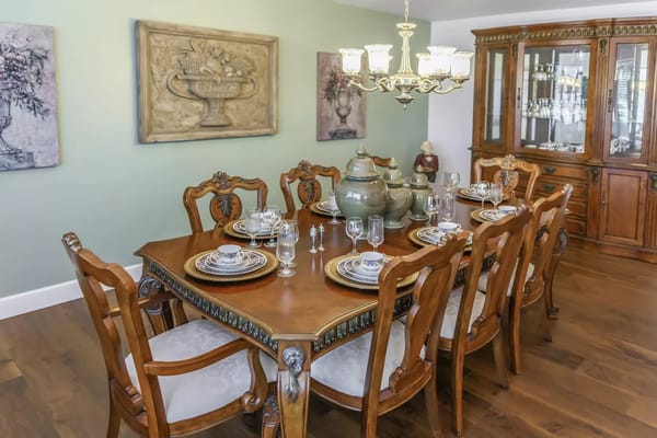 Wooden dining table set with fine china and glassware in a dining room