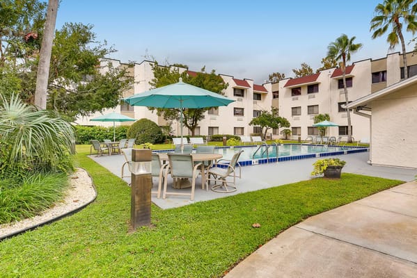 Outdoor pool area with seating and umbrellas