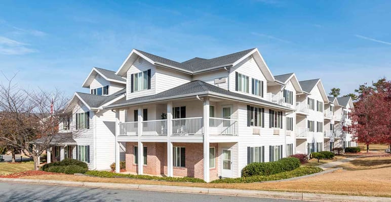 Exterior of Solista Hickory senior living facility featuring white building and balconies.
