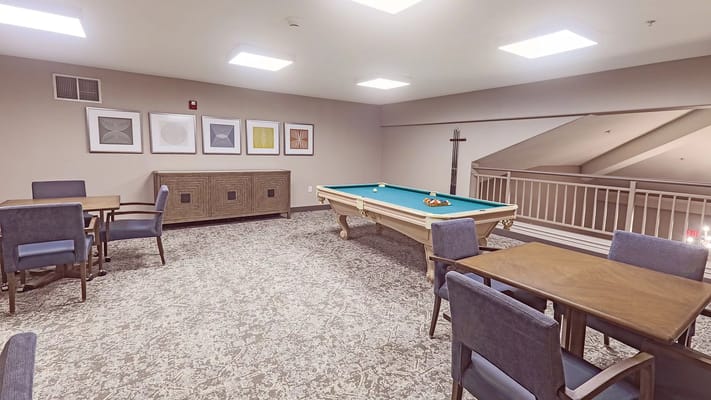 Interior view of the game room with a pool table and dining tables
