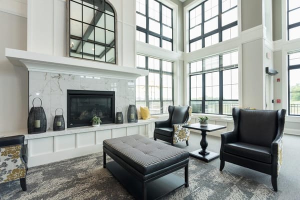Modern lobby with seating and fireplace at Holland Farms senior living facility.