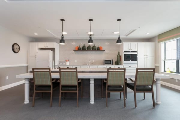 Spacious kitchen area with a long table and modern appliances