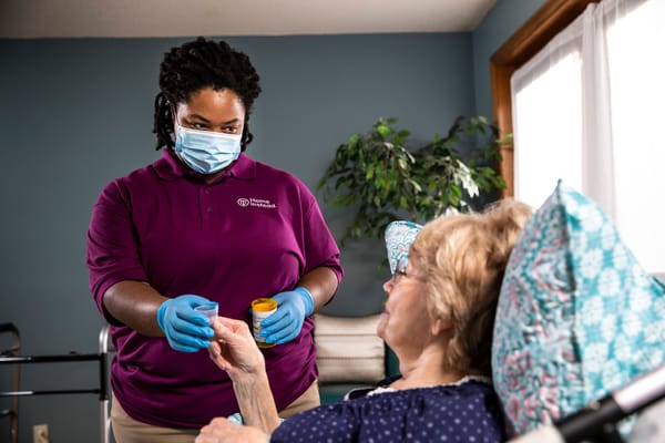Caregiver assisting a resident in an indoor setting