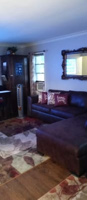 A cozy living room with a brown leather couch and decorative pillows