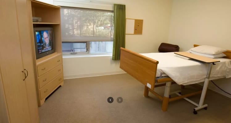 A private room with a bed and a television