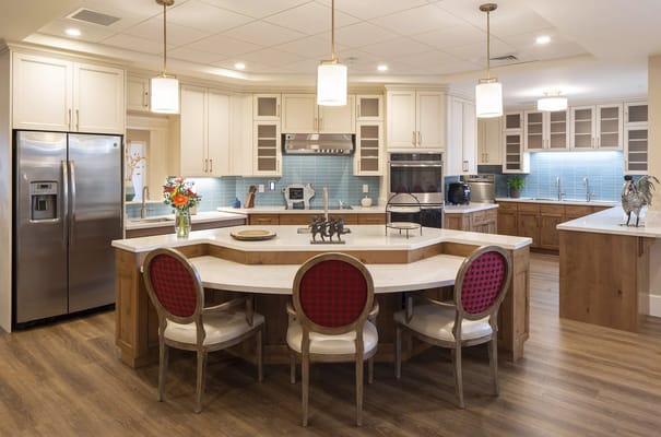 Modern kitchen with seating and appliances at Beatrice Hover Assisted Living