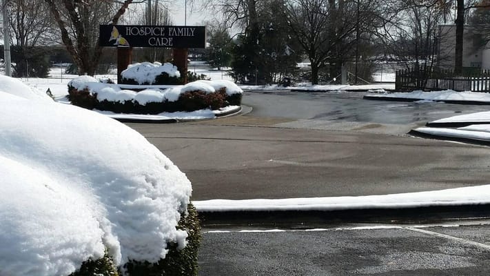 Entrance sign of Hospice Family Care surrounded by snow
