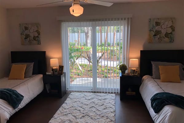 Bright resident room with two beds and a view of the garden