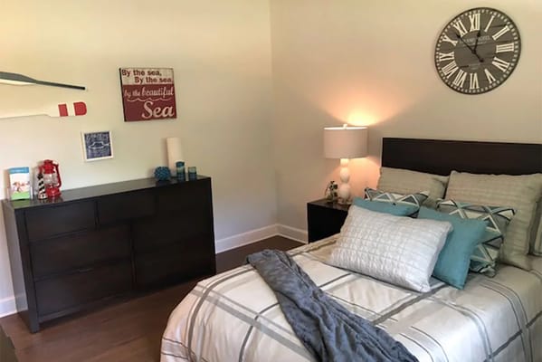 Well-decorated resident room with a bed and wall art