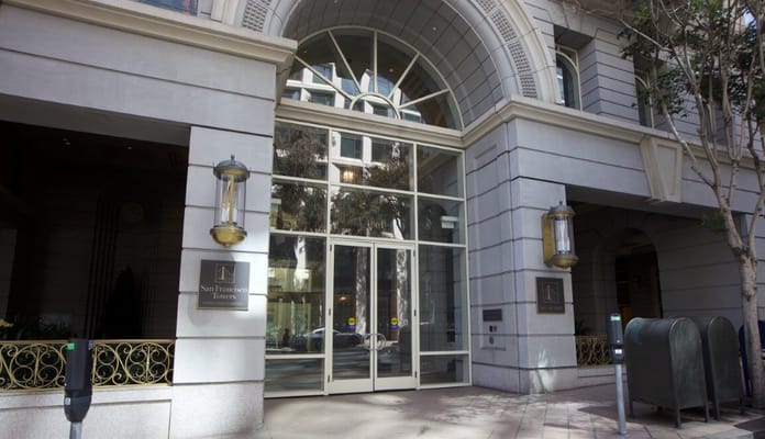 Main entrance of San Francisco Towers with glass doors and architectural details.