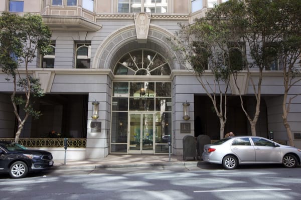 Main entrance of San Francisco Towers with glass doors and decorative architecture.