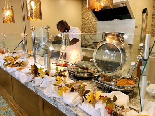 Chef serving food in a dining area