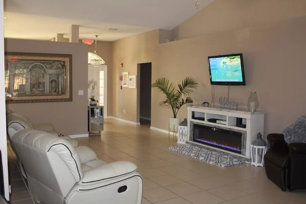 Spacious living room with reclining chairs and a TV