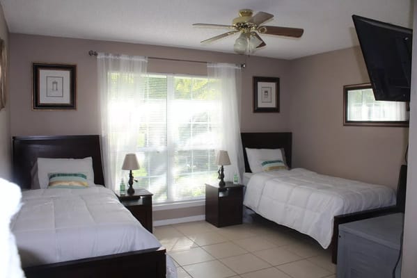 A cozy twin bedroom with two beds and bedside lamps.