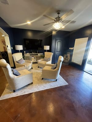 Lounge area with four chairs and a television.
