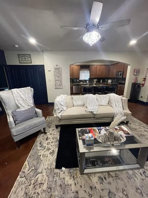 Cozy living room with a couch, armchair, and coffee table at Go Giver Assisted Living.