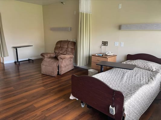 Interior view of a private resident room with a bed and chair