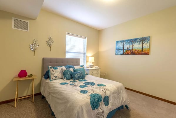 Cozy bedroom with a floral duvet and artwork
