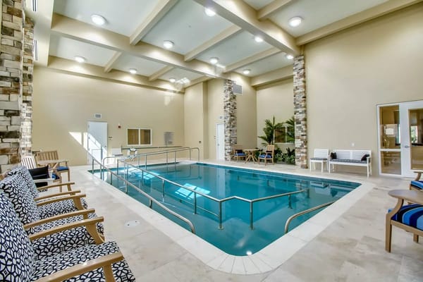 Indoor pool area with seating and natural lighting