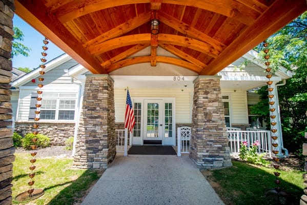 Main entrance with a wooden awning and stone pillars