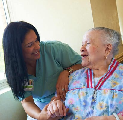 A caregiver interacting with an elderly resident indoors