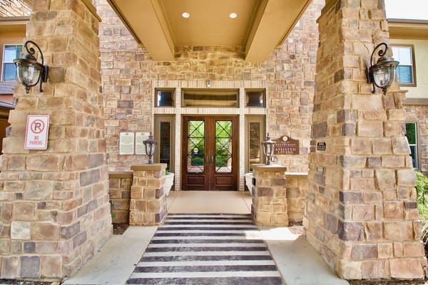 Entrance of Isle at Watercrest Mansfield with stone pillars and double doors