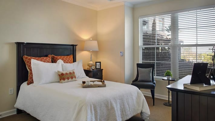 Well-decorated private resident room with bed and desk
