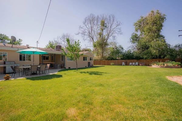 Spacious backyard with patio seating and green grass at Jaxpointe at Flower Court