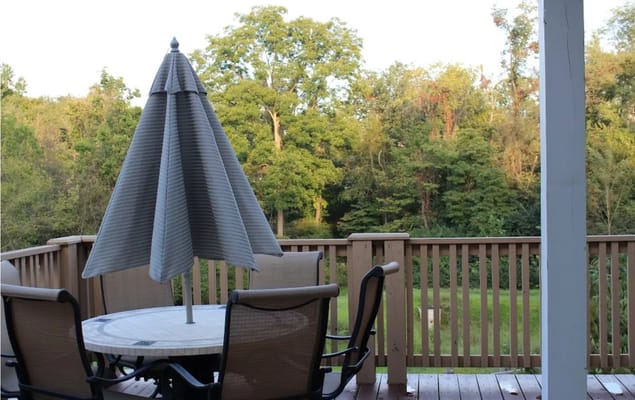 Deck area with table and chairs overlooking greenery