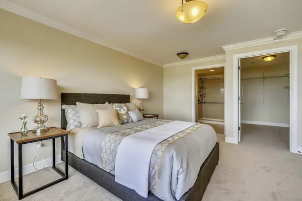 A well-decorated bedroom with a bed, nightstands, and a spacious closet