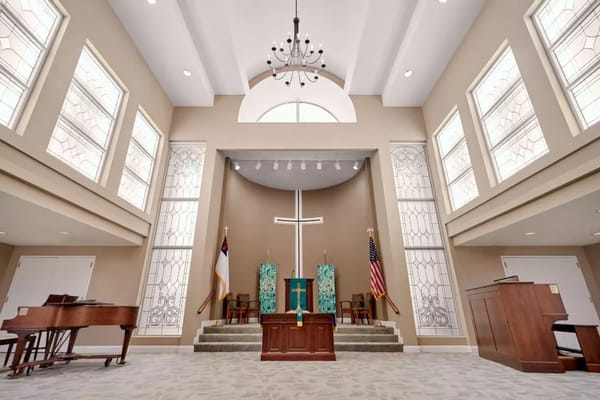 Interior view of a chapel with a cross and seating