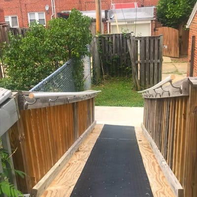 Wooden ramp leading to the backyard with a fence visible in the background.