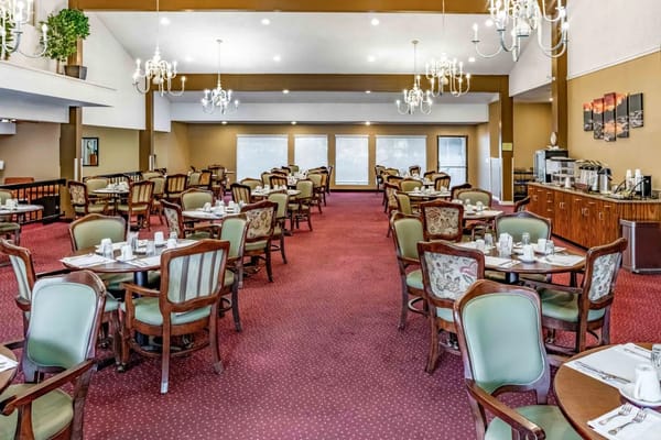 Spacious dining room with tables and chairs at Kamlu Retirement Inn