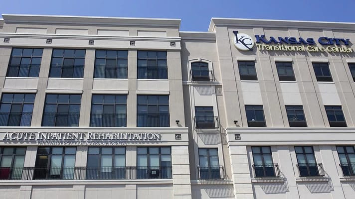 Facade of Kansas City Transitional Care Center with balcony and signage