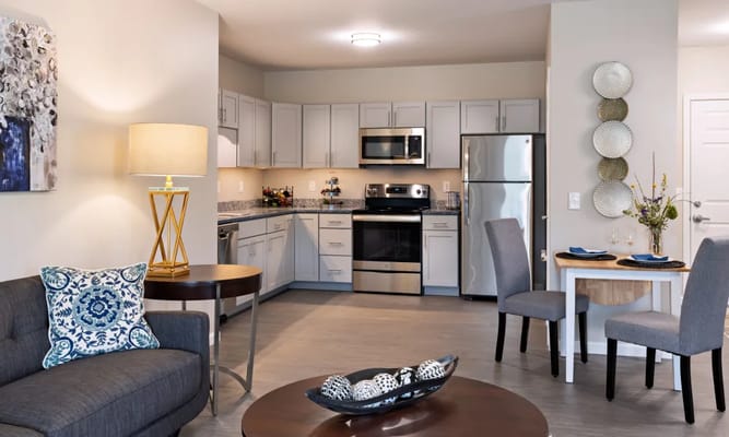 Modern kitchen with dining area in Keystone Place senior living facility