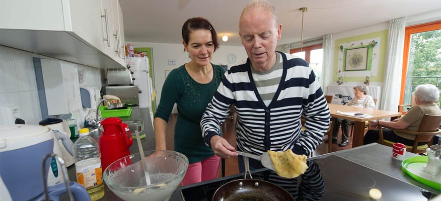 Staff assisting a resident in the kitchen