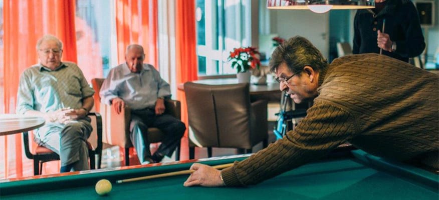 Residents playing billiards in a common area